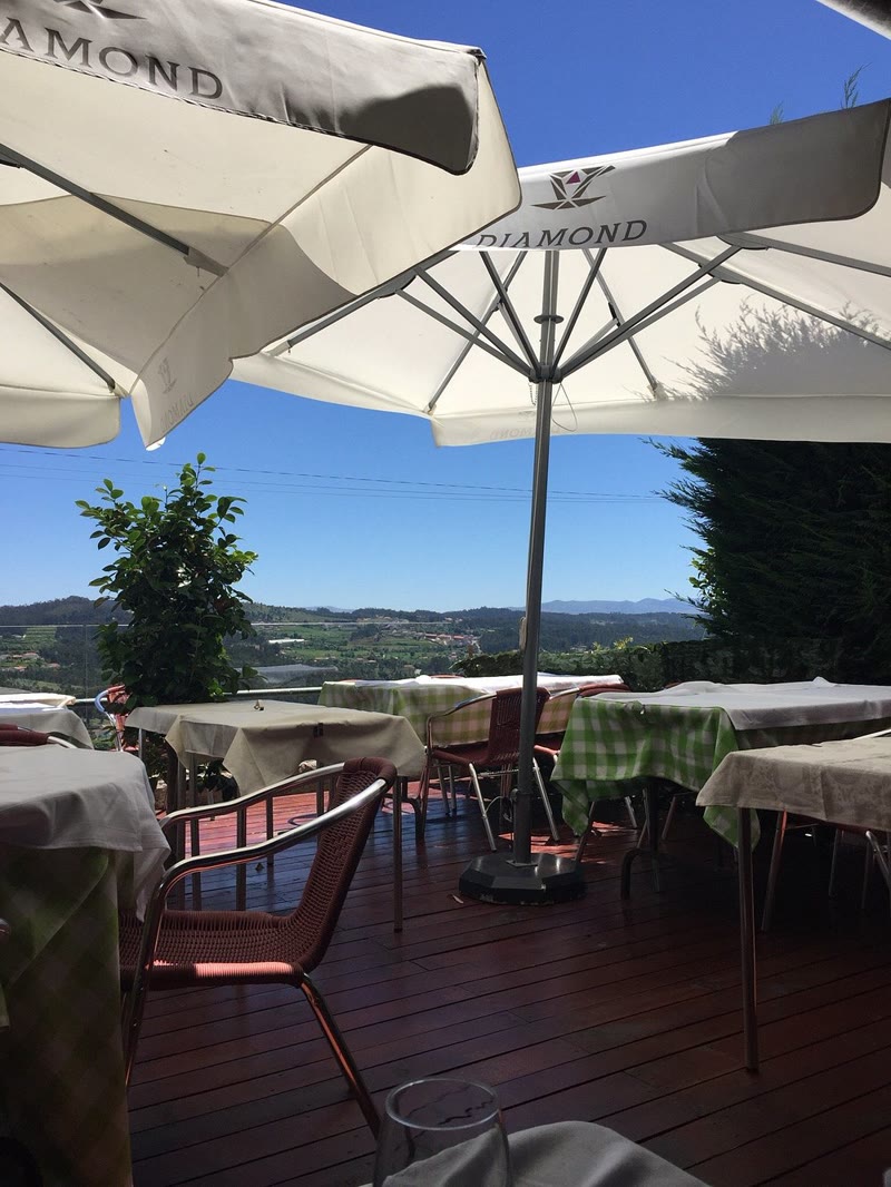 Terraço exterior com guarda-sóis e vista sobre o vale