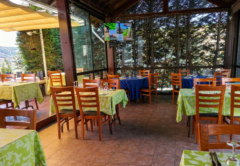 Sala envidraçada com vista sobre árvores e vale